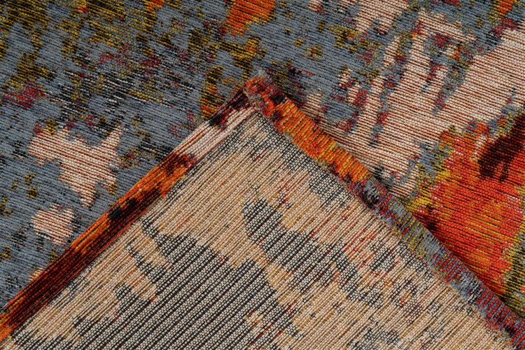 Nahaufnahme eines gewebten Teppichs mit abstraktem Muster und einer umgeklappten Ecke, die die Textur der Rückseite zeigt.