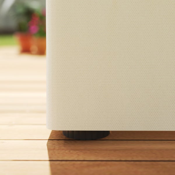 Detailaufnahme eines Gartenmöbels mit beigem Stoffbezug und schwarzem Standfuß auf einer Holzterrasse.