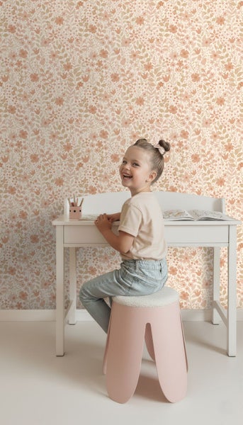 Ein Kinderzimmer mit Blumentapete, Kinderschreibtisch und Hocker