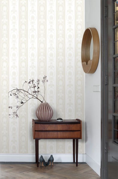 Raumansicht mit gestreifter Tapete, Kommode und Dekoration