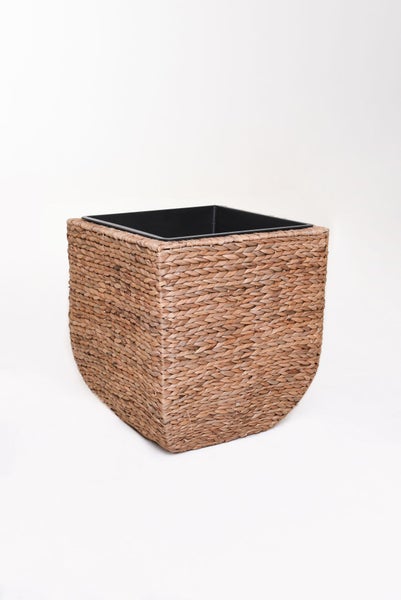 Quadratischer Pflanzkübel aus Naturgeflecht mit schwarzem Kunststoffeinsatz.