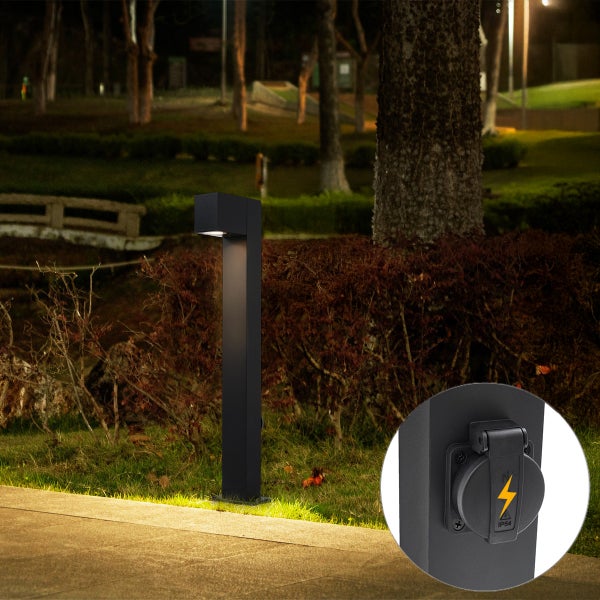 Moderne schwarze Außenleuchte als Wegeleuchte im Garten bei Nacht mit integrierter Steckdose und Schutzklappe.