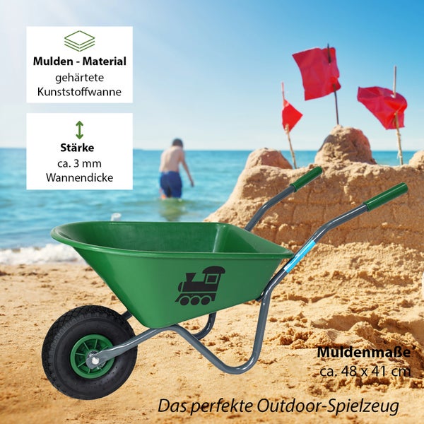 Grüne Kinderschubkarre mit Zugmotiv vor Sandburg am Strand