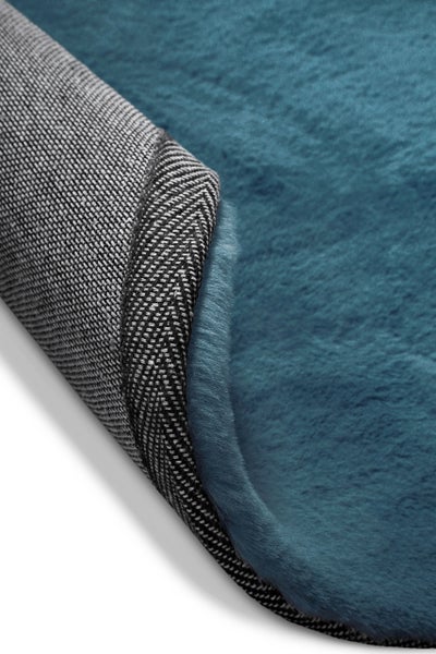 Weicher Hochflor-Teppich in Blau mit gewebter Rückseite und verstärktem Rand.