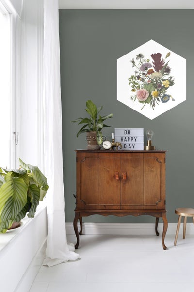 Szene mit Holzschrank, Topfpflanzen, Dekorationen und einem sechseckigen Blumenbild an der Wand.