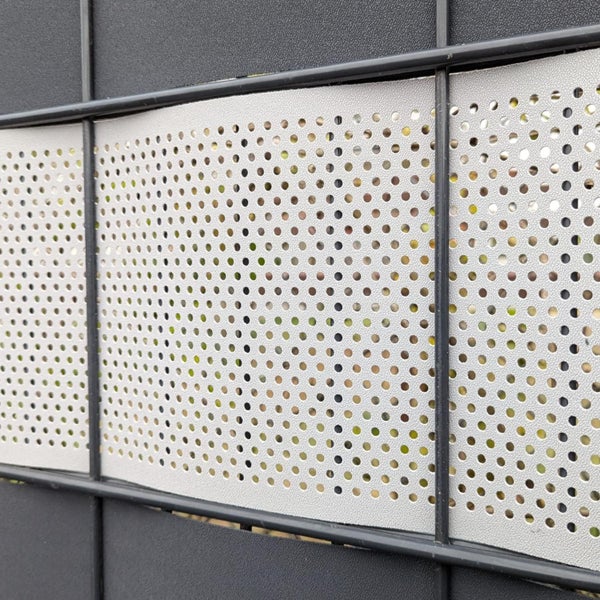 Detailansicht eines Zauns mit gelochten Sichtschutzelementen