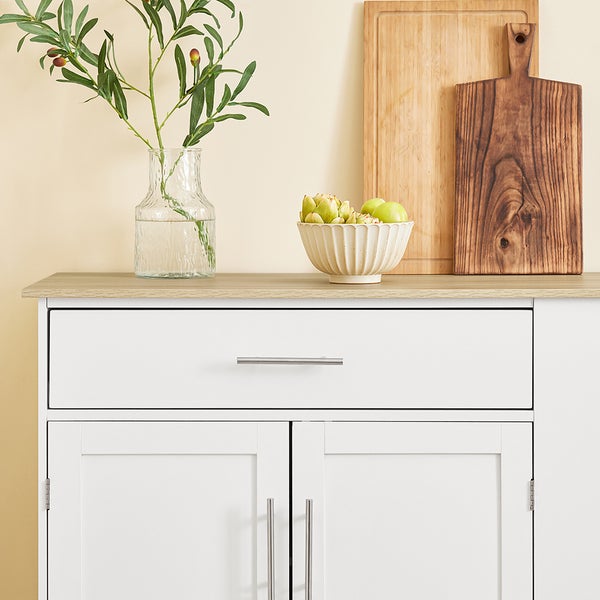 Küchenschrank mit Schublade und Türen, dekoriert mit Vase, Schale und Schneidebrettern.