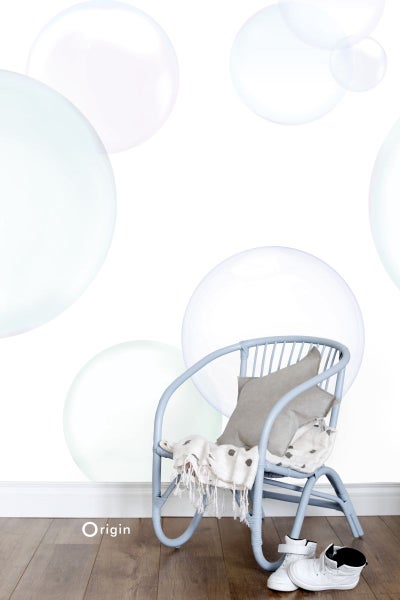 Dekorative Kinderszene mit Stuhl, Kissen, Decke und Schuhen vor einer Wand mit Blasenmuster.