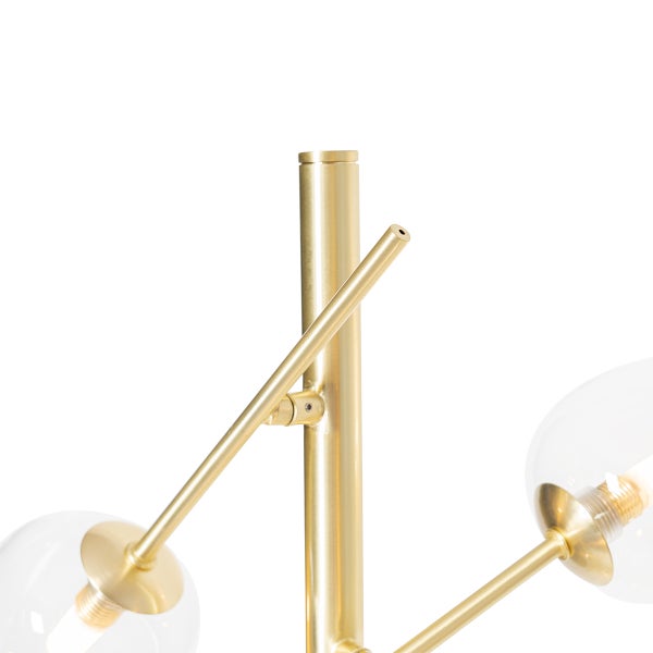 Detailaufnahme einer goldenen Stehlampe mit Glaskugeln.