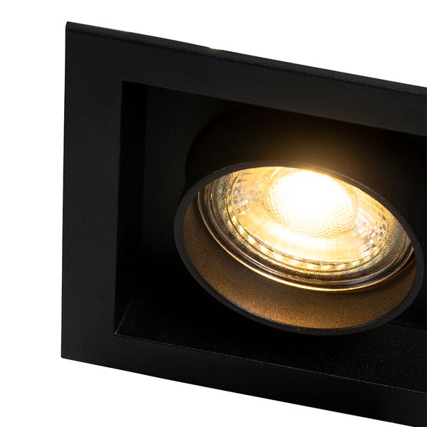 Detailaufnahme eines schwarzen eckigen Einbaustrahlers mit eingeschalteter warmweißer LED.