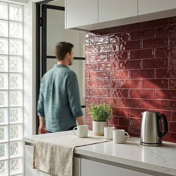 Moderne Küche mit glänzenden rechteckigen Wandfliesen, einer Arbeitsplatte aus Marmoroptik und einem Wasserkocher.