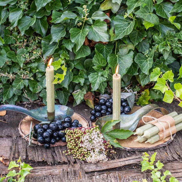 Dekorative Szene mit Kerzen, Beeren und Blättern auf Holztisch
