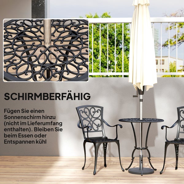 Ein Paar sitzt mit einer Katze auf einer hellen Terrasse in modernen Gartenstühlen mit Polstern und einem runden Tisch mit Glasplatte.