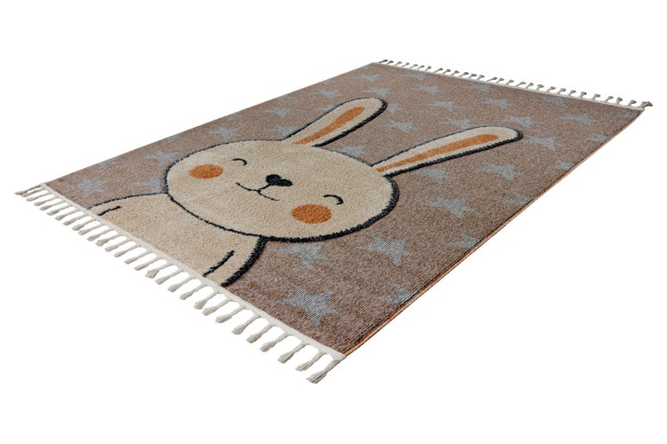 Rechteckiger Kinderteppich mit Hasenmotiv und Sternenmuster sowie Fransen an den kurzen Seiten.