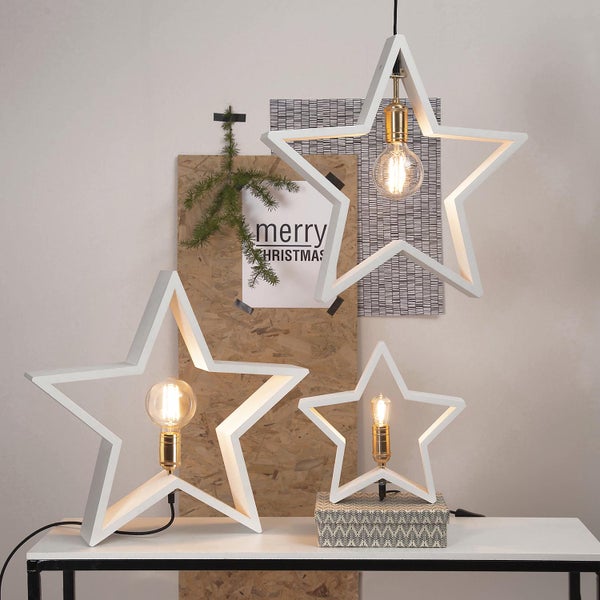 Dekorative Sternleuchten in verschiedenen Größen auf einem Tisch, bestehend aus einer Hängeleuchte und zwei Tischleuchten