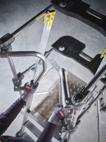 Person steigt auf eine Altrex Leiter mit Plattform