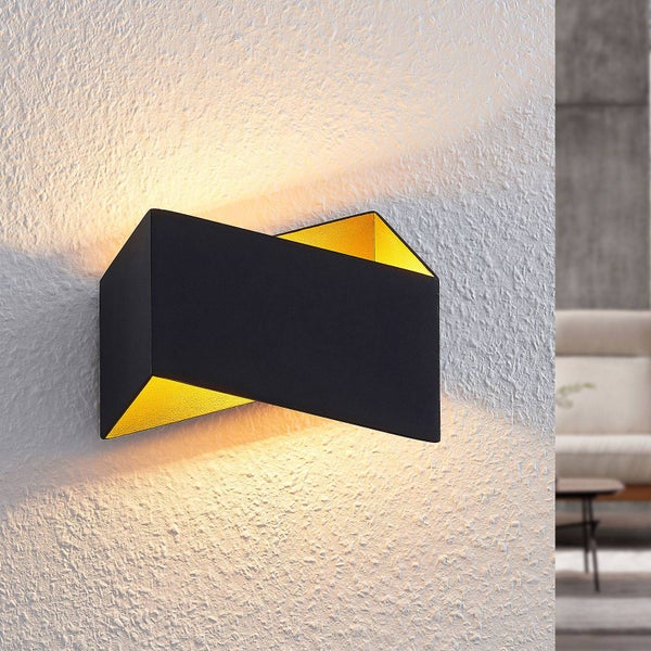 Moderne schwarze Wandleuchte mit goldener Innenseite und Lichtstrahl nach oben und unten auf einer strukturierten Wand.