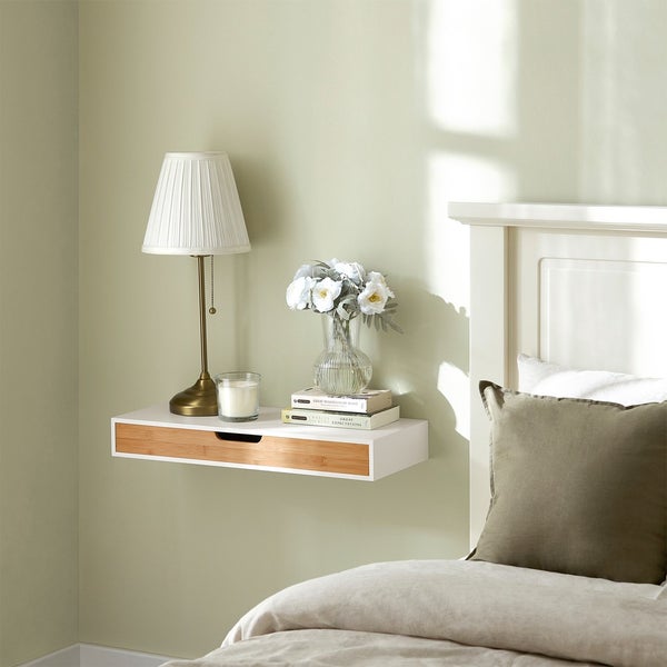 Schlafzimmer mit Nachttisch mit Schublade, Lampe, Kerze und Blumenvase