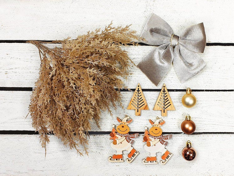 Set mit Weihnachtsdekoration bestehend aus künstlichem Tannenzweig, Stoffschleife, zwei Holzanhängern als Tannenbaum, zwei Rentierfiguren und Kugeln.