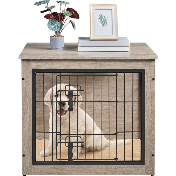 Hund sitzt in einer Hundebox mit Tischplatte und Gittertür.