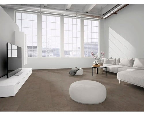 Heller, geräumiger Wohnraum im Loft-Stil mit großen Fenstern, weißem Sofa und braunem Bodenbelag in Fliesenoptik.