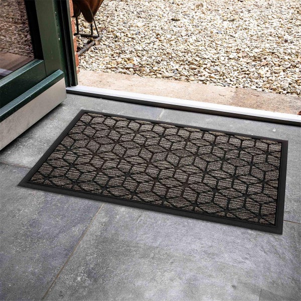 Schmutzfangmatte mit geometrischem Muster vor einer Tür