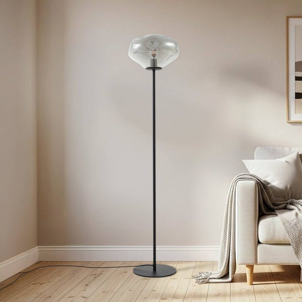 Stehleuchte mit Glasschirm auf schwarzem Metallgestell im Wohnzimmer