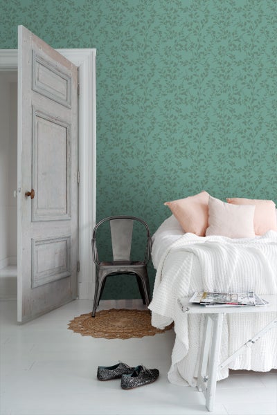 Schlafzimmer mit gemusterter Tapete, Bett und Beistelltisch