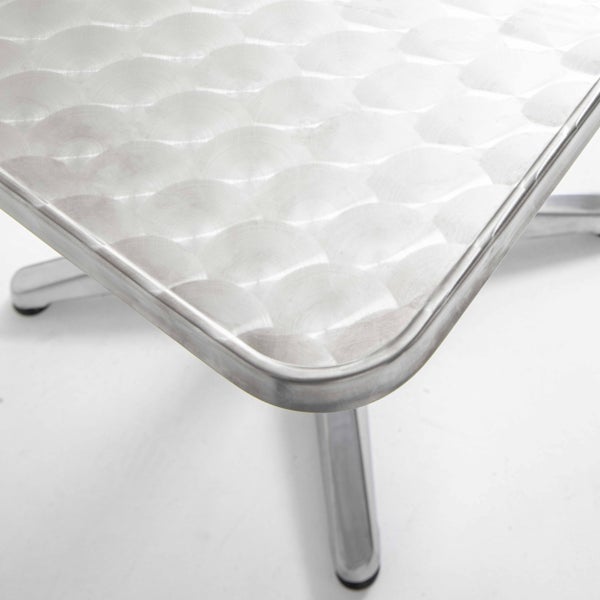 Aluminium-Bistrotisch mit kreisförmig geschliffener Oberfläche und abgerundeten Ecken.