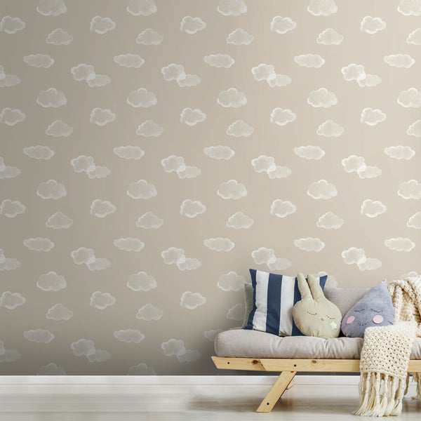 Tapete mit Wolkenmuster im Kinderzimmer hinter einem Holzsofa mit Kissen und Strickdecke.