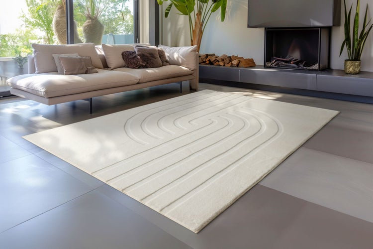 Moderner Wohnbereich mit einem rechteckigen Teppich mit geometrischem Reliefmuster auf einem gefliesten Boden vor einem Sofa und Kamin.