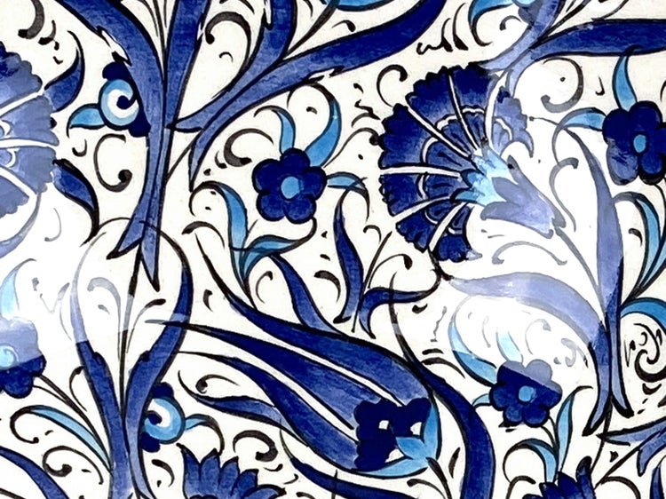 Dekorfliese mit floralem Muster in Blau und Schwarz