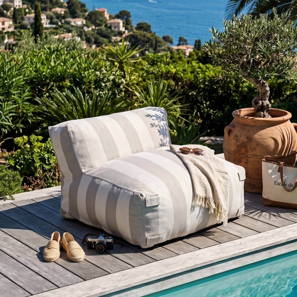 Gestreifter Outdoor-Sitzsack auf einer Holzterrasse am Pool mit Blick auf das Meer.