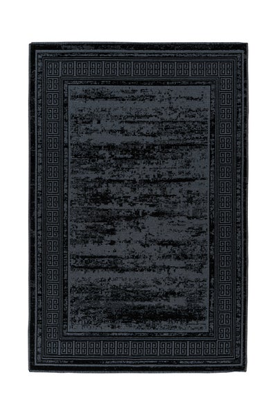 Moderner Wohnraum mit dunkelgrauem Teppich im Vintage-Look mit griechischem Muster. Sofa, Couchtisch und Schaukelstuhl auf hellem Holzboden.