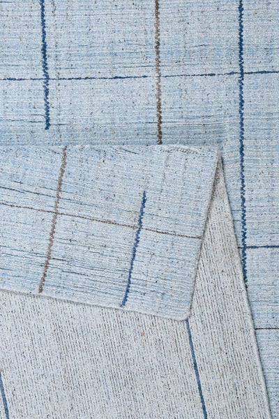 Strukturierter blauer Teppich mit geometrischem Muster und verschiedenen Florhöhen.