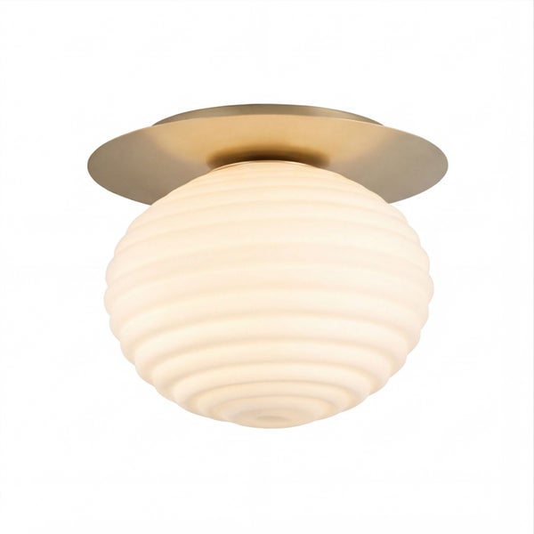 Deckenleuchte mit weißem geriffeltem Glasschirm und runder Metallhalterung in Messingoptik.