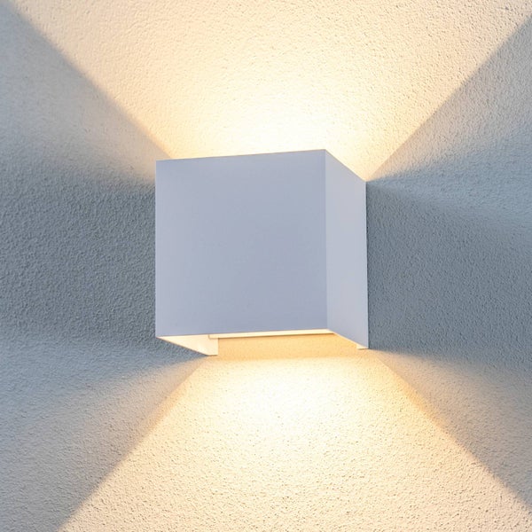 Quadratische LED-Wandleuchte in Weiß mit Lichtaustritt nach oben und unten an einer strukturierten Wand.
