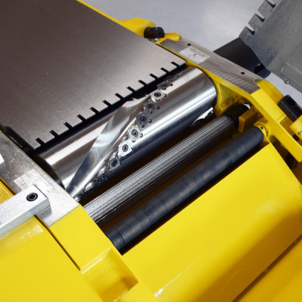 Detailansicht einer Hobelmaschine mit Schneidwelle und Vorschubwalze