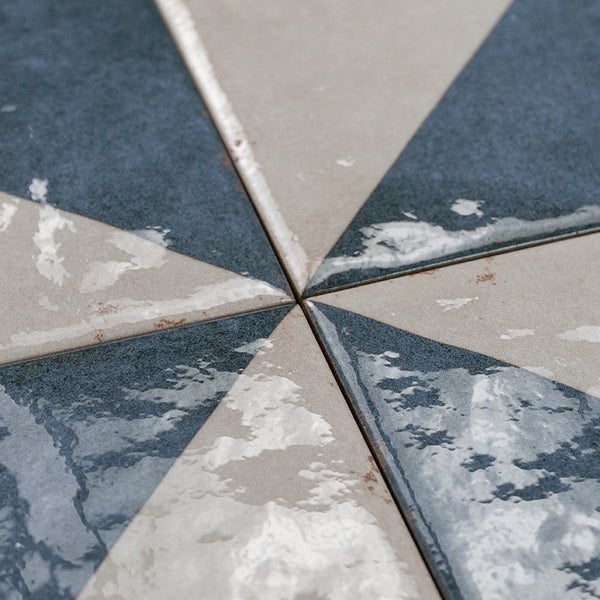Geometrische Wandfliesen mit dreieckigem Muster und einer Mischung aus matten und glänzenden Oberflächenstrukturen
