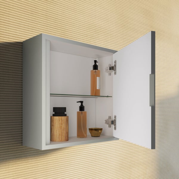 Wandschrank mit offener Spiegeltür und Glasboden, befüllt mit Badezimmeraccessoires vor einer gerillten Wand.