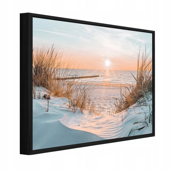 Wandbild mit Strandmotiv bei Sonnenuntergang in einem schwarzen Rahmen.