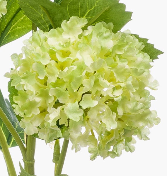 Künstliches Gras in einem dunklen, runden Kunststofftopf.