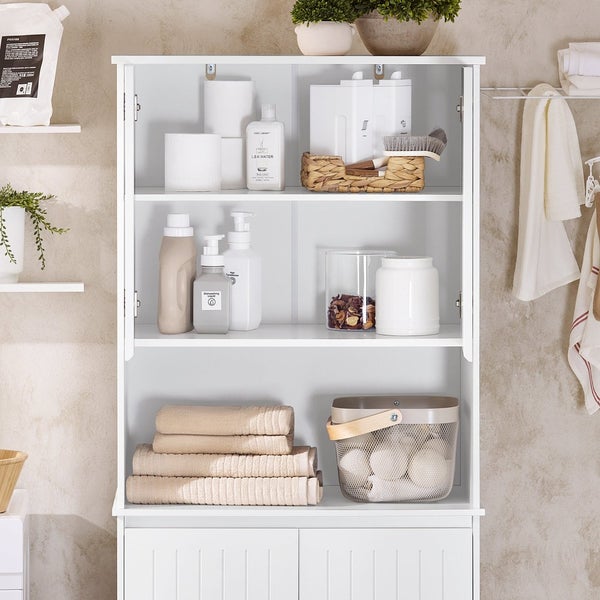 Weißer Badschrank mit Handtüchern und Badezimmerzubehör