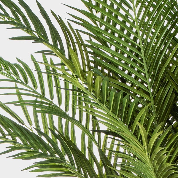 Detailansicht von grünen Palmwedeln einer Kunstpalme mit schmalen Blättern.