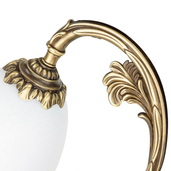 Detailaufnahme einer Wandleuchte mit floralem Design und weißem Lampenschirm