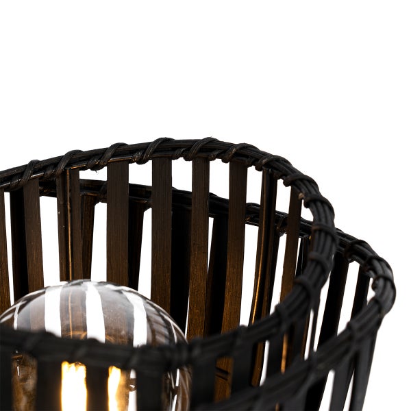 Detailansicht einer Lampe mit Lampenschirm aus Rattan