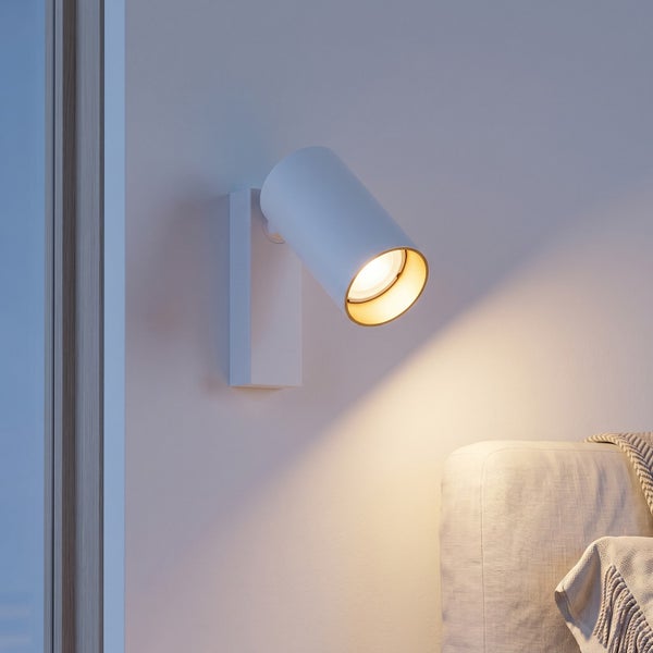 Moderne Wandleuchte in zylindrischer Form als Leselicht neben einem Sofa montiert für eine gemütliche Akzentbeleuchtung.