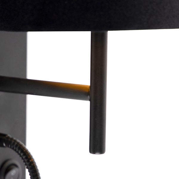 Detailaufnahme einer schwarzen Wandleuchte mit Schirm und verstellbarem Arm.
