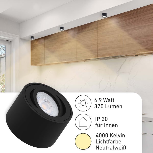 Schwarzer LED-Aufbaustrahler in einer hellen Küche über Holzschränken montiert. 4,9 Watt, 370 Lumen, IP 20 für innen, 4000 Kelvin neutralweißes Licht.