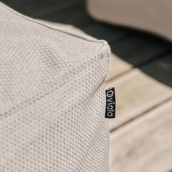 Nahaufnahme einer Kissenecke aus strukturiertem Stoff mit Oviala Logo